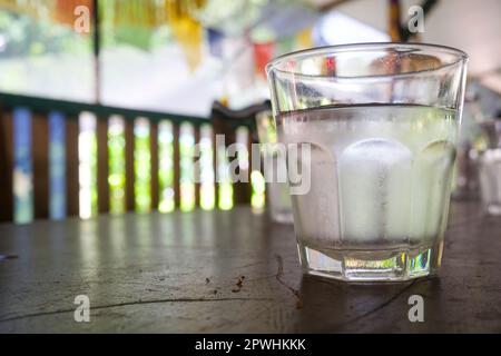 Bicchiere di acqua fredda in un ambiente tropicale Foto Stock