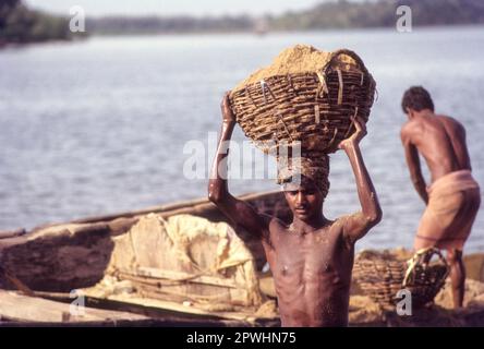 Raccolta di sabbia dal fiume Gurpura vicino Sultan Battery, Mangalore, Karnataka, India Foto Stock