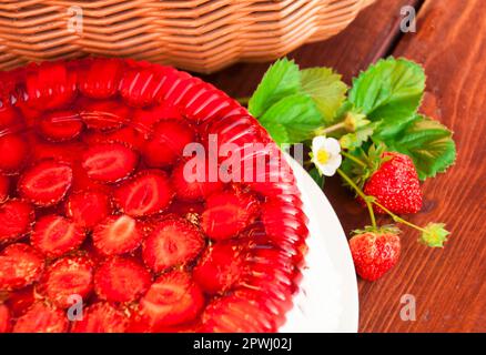 Crostata con fragole e panna montata decorata con foglie di menta. Sfondo di legno. Vista dall'alto. Vicino al ferro Foto Stock