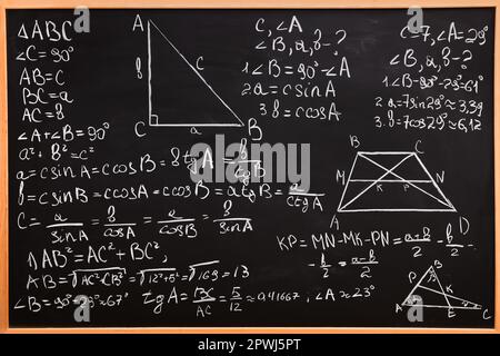 Diverse formule matematiche scritte con il gesso sulla lavagna Foto Stock