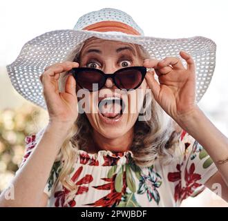 Che cosa hai appena detto. Ritratto corto di una donna anziana attraente che guarda sorpreso mentre indossa occhiali da sole all'aperto Foto Stock