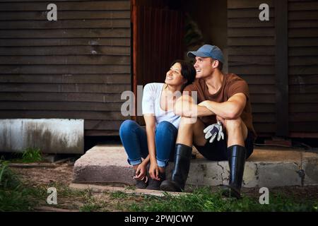 Il nostro amore per l'agricoltura ci ha Uniti. Foto a tutta lunghezza di una giovane coppia felice che si unisce e che passa il tempo insieme all'aperto nella loro fattoria Foto Stock