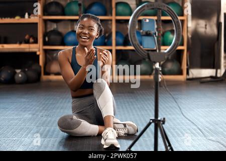 Male essere condividere un sacco di suggerimenti per l'allenamento con tutti voi oggi. una giovane donna sportiva che si registra mentre si esercita in palestra Foto Stock