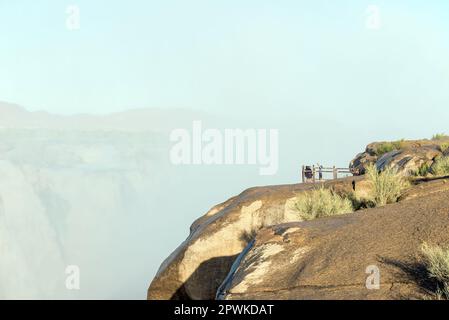 Parco Nazionale di Augrabies, Sudafrica - 27 febbraio 2023: I turisti sono inzuppati dallo spruzzo di acqua che cade in un punto di vista presso le cascate di Augrabies i Foto Stock