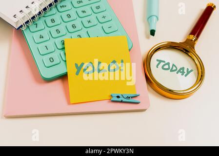 Scrittura visualizzando testo Yolo, Word scritto in stand per voi vivere solo una volta fase popolare tra studenti e ragazzi Foto Stock