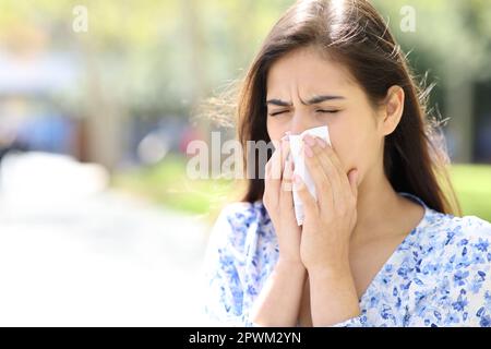 Donna malata che soffia o tosse sul tessuto della strada Foto Stock