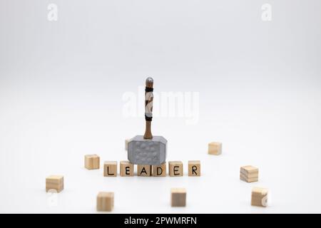 Il martello è in piedi sui cubi di legno con il CAPO parola su sfondo bianco Foto Stock