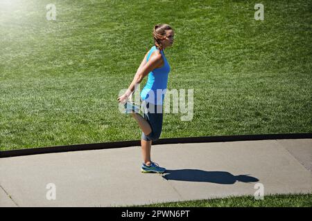 Preparatevi a partire. una giovane runner allettante che si esercita all'aperto. Foto Stock