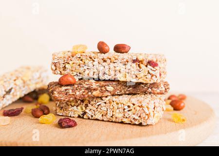 Vari barrette di muesli su sfondo tavolo. Barrette di cereali. Bar per la colazione superfood con avena, noci e frutti di bosco, primo piano. Concetto superfood. Foto Stock