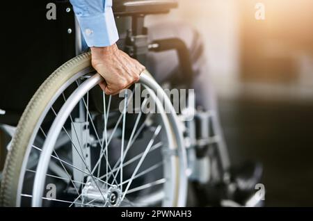 Ci muovo. Primo piano di un uomo irriconoscibile seduto su una sedia a rotelle Foto Stock