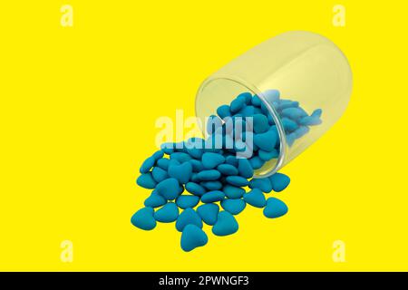 Vetro rovesciato con caramelle a forma di cuore blu (primo piano) isolate su sfondo giallo. Simboli di Stato dell'Ucraina. Vista dall'alto Foto Stock
