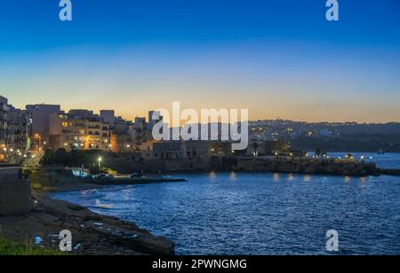 Malta, St Paul's Bay: Vista panoramica notturna della St Paul's Bay, una popolare destinazione turistica nella parte nord-occidentale di Malta. Foto Stock