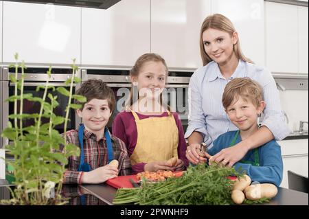 Studenti e insegnante di patate che pelano la patata con la pelatrice di patate in una lezione di economia domestica, Baviera, Germania Foto Stock