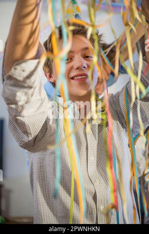 Adolescente con carta streamers alla festa di compleanno Foto Stock