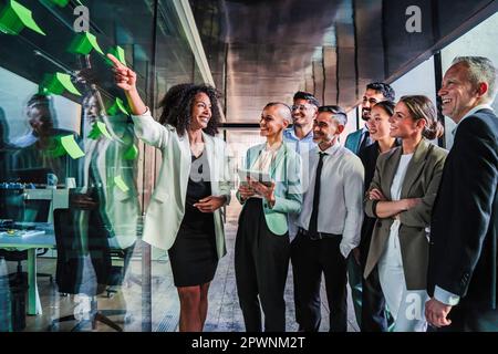 Un gruppo di persone aziendali avvia il brainstorming del lavoro di squadra utilizzando la posta in ufficio per una felice riunione di collaborazione. Donna d'affari che spiega la nuova strategia o programma di vendita ai suoi colleghi. Foto di alta qualità Foto Stock