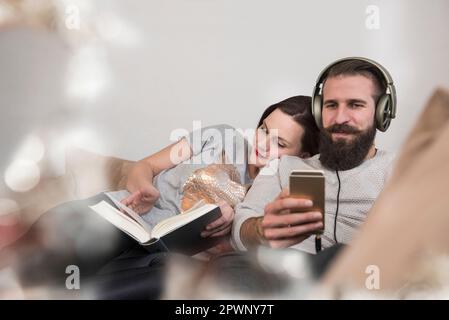 Donna che legge il diario e si appoggia alla spalla del marito Foto Stock