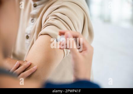 Anziano asiatico che riceve vaccino contro il coronavirus con infermiera, medico che fa l'iniezione con siringa all'anziano uomo in clinica o in ospedale, medico e lui Foto Stock