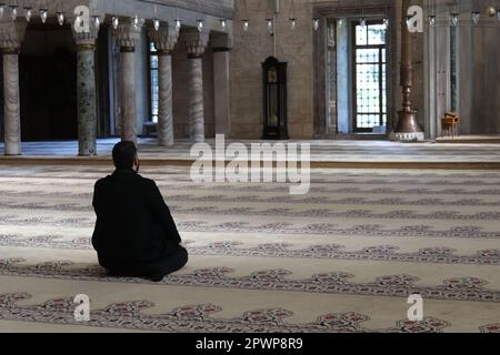 Un uomo prega in una moschea sulle ginocchia. Foto Stock