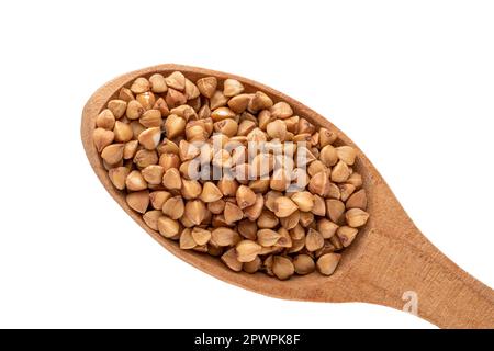 Grano saraceno crudo in un cucchiaio di legno isolato su sfondo bianco, macro, vista dall'alto. Foto Stock