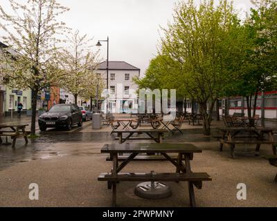 Tavoli da picnic in Nevill Street, nella città commerciale di Abergavenny Monmouthshire Wales UK, inutilizzati in una giornata umida Abergavenny Gateway to Wales Foto Stock