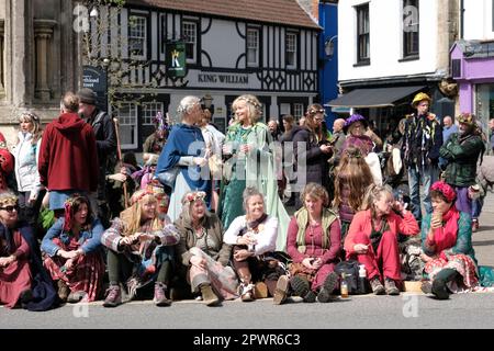 Glastonbury, Somerset, Regno Unito. 1st maggio 2023. Le ragazze sono sedute al sole del giorno di maggio. Le celebrazioni pagane di Beltane si svolgono ogni anno tra l'equinozio di primavera e di estate il 1st maggio. Le persone si incontrano, si vestono di verde, si godono una sfilata, musica e danza. Il festival ha le sue radici nelle prime celebrazioni stagionali gaeliche, si inserisce bene con la comunità di nuova età che questa piccola città Somerset attira. Essi si riuniscono intorno alla croce del mercato in città, il palo di maggio è presentato al re di maggio e alla regina che insieme con gli uomini verdi portano il palo di maggio al pozzo del Calice. Merito: Sig. Standfast/Alamy Foto Stock