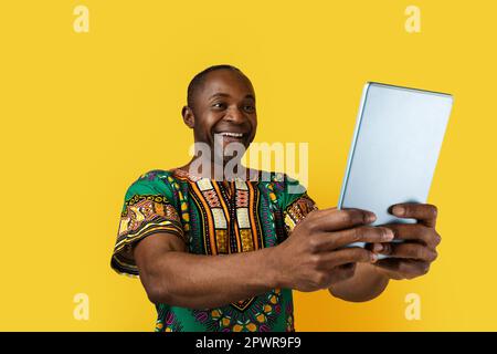 Felice uomo nero di mezza età che tiene un tablet digitale Foto Stock