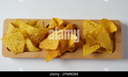 Doritos è una marca americana di patatine aromatizzate alla tortilla. Corn chips doritos speziato su una tavola di legno. Foto Stock