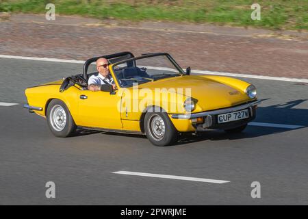 1980 80s ottanta giallo TRIONFA SPITFIRE sportiva britannica che viaggia sull'autostrada M6, Regno Unito Foto Stock