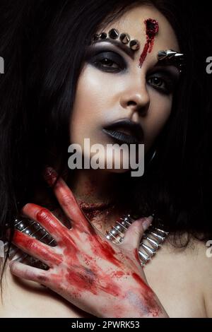 Demon girl with a bullet in the head and her throat cut. An image for Halloween. Photos shot in studio Stock Photo