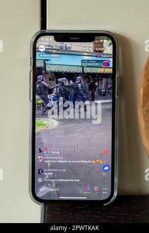 Immagini di un iphone12 live streaming le rivolte a Parigi il 1st maggio 2023, anti-macron Foto Stock