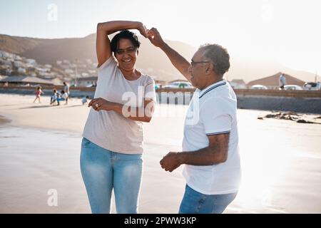 Lascia ballare come nessuno che guarda. una coppia matura che trascorre del tempo in spiaggia Foto Stock