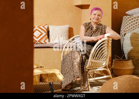 Donna in pensione si siede in autentico centro orientale stile interno Foto Stock