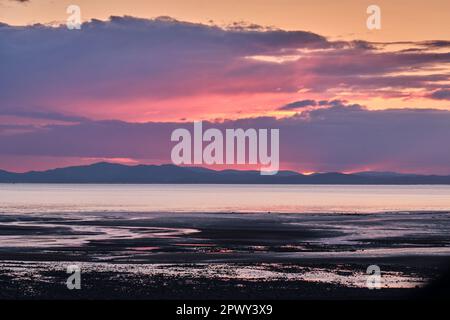 Le colline di Dumfries e Galloway al tramonto, visto attraverso il Solway Firth da Allonby, Cumbria Foto Stock