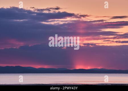 Le colline di Dumfries e Galloway al tramonto, visto attraverso il Solway Firth da Allonby, Cumbria Foto Stock