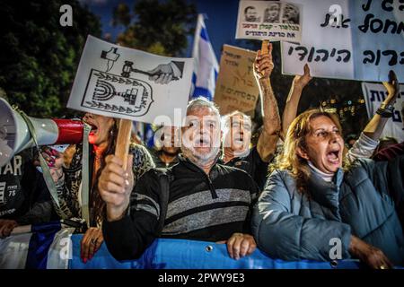 Tel Aviv, Israele. 30th Apr, 2023. I manifestanti sono in possesso di cartelli e slogan cantanti mentre dimostrano contro l'ex capo della giustizia Aharon Barak a Tel Aviv. Centinaia di manifestanti della riforma pro e anti-giudiziaria si sono riuniti domenica fuori dalla casa dell’ex presidente della Corte di giustizia Aharon Barak, dopo che i gruppi anti-riforma hanno espresso preoccupazione per la sua sicurezza all’inizio della giornata. Credit: SOPA Images Limited/Alamy Live News Foto Stock