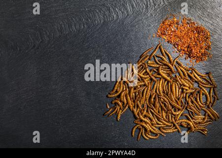 Farina di verme con peperoncino. Vermi salati fritti. Worm al forno. Alimentazione sana. Foto Stock