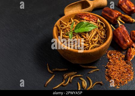 Farina di verme con peperoncino. Vermi salati fritti. Worm al forno. Alimentazione sana. Foto Stock