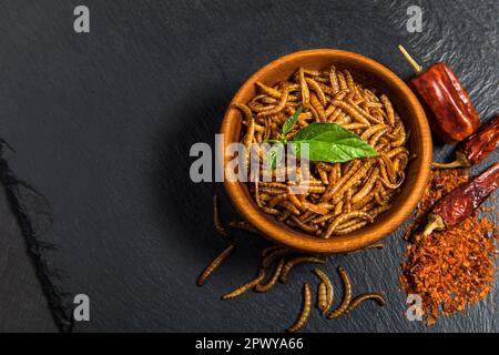 Farina di verme con peperoncino. Vermi salati fritti. Worm al forno. Alimentazione sana. Foto Stock