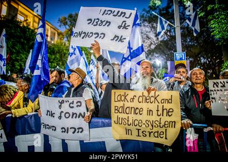 Tel Aviv, Israele. 30th Apr, 2023. I manifestanti hanno fatto sventolare la bandiera israeliana e hanno in mano cartelli contro l'ex capo della giustizia Aharon Barak a Tel Aviv. Centinaia di manifestanti della riforma pro e anti-giudiziaria si sono riuniti domenica fuori dalla casa dell’ex presidente della Corte di giustizia Aharon Barak, dopo che i gruppi anti-riforma hanno espresso preoccupazione per la sua sicurezza all’inizio della giornata. Credit: SOPA Images Limited/Alamy Live News Foto Stock