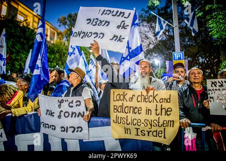 Tel Aviv, Israele. 30th Apr, 2023. I manifestanti hanno fatto sventolare la bandiera israeliana e hanno in mano cartelli contro l'ex capo della giustizia Aharon Barak a Tel Aviv. Centinaia di manifestanti della riforma pro e anti-giudiziaria si sono riuniti domenica fuori dalla casa dell’ex presidente della Corte di giustizia Aharon Barak, dopo che i gruppi anti-riforma hanno espresso preoccupazione per la sua sicurezza all’inizio della giornata. (Foto di Eyal Warshavsky/ SOPA Images/Sipa USA) Credit: Sipa USA/Alamy Live News Foto Stock