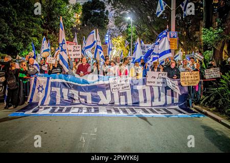 Tel Aviv, Israele. 30th Apr, 2023. I manifestanti hanno fatto sventolare le bandiere israeliane e hanno una bandiera mentre manifestano contro l'ex capo della giustizia Aharon Barak a Tel Aviv. Centinaia di manifestanti della riforma pro e anti-giudiziaria si sono riuniti domenica fuori dalla casa dell’ex presidente della Corte di giustizia Aharon Barak, dopo che i gruppi anti-riforma hanno espresso preoccupazione per la sua sicurezza all’inizio della giornata. (Foto di Eyal Warshavsky/ SOPA Images/Sipa USA) Credit: Sipa USA/Alamy Live News Foto Stock