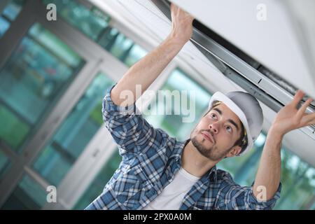 L'uomo installare controsoffitti in casa Foto Stock