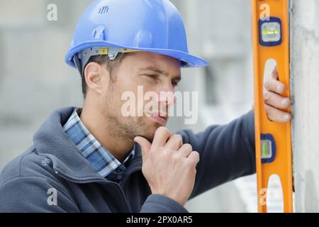 un costruttore che usa un livello Foto Stock