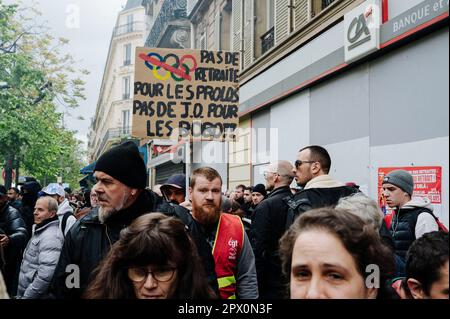 Parigi, Francia. 01st maggio, 2023. Jan Schmidt-Whitley/le Pictorium - manifestazione del giorno di Maggio a Parigi - 1/5/2023 - Francia/Parigi/Parigi - Un dimostratore passa con un segno che si oppone allo svolgimento delle Olimpiadi del 2024 a Parigi. Grande mobilitazione per il 1st maggio a Parigi, il CGT contava 2,3 milioni di manifestanti in Francia, di cui 550.000 a Parigi, il Ministero degli interni contava 782.000 dimostranti, di cui 112.000 nella capitale. Gli scontri tra i dimostranti e la polizia si sono verificati davanti alla marcia. Credit: LE PICTORIUM/Alamy Live News Foto Stock