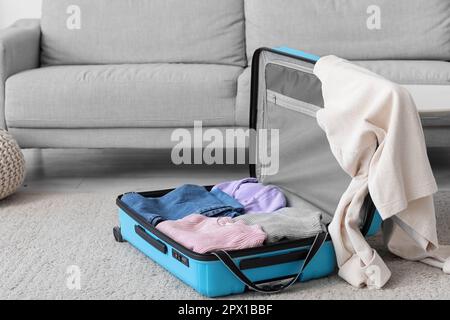 Valigia aperta con abiti in soggiorno Foto stock - Alamy