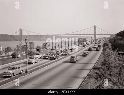 1940S 1950S AUTO SU HUDSON RIVER PARKWAY GUARDANDO VERSO NORD VERSO GEORGE WASHINGTON BRIDGE SUL FIUME HUDSON NEW YORK NY USA - M3601 FST001 HARS NYC CONCETTUALE NEW YORK AUTOMOBILI CITTÀ DIVISE VEICOLI CHE COLLEGANO IL NORD NEW JERSEY NEW YORK CITTÀ FORT LEE LANES PARKWAY, NERO E BIANCO, SOSPENSIONE IN VECCHIO STILE DEL FIUME HUDSON Foto Stock