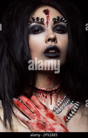 Demon girl with a bullet in the head and her throat cut. An image for Halloween. Photos shot in studio Stock Photo