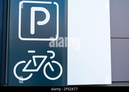 Simbolo di un parcheggio per biciclette dipinto sulla facciata di un edificio moderno, da vicino Foto Stock