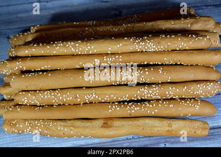 Mucchio di grissini, detti anche grissini, grissino o bastoncini da immersione, bastoncini a matita di pane fresco e secco al forno con semi di sesamo, fette biscottate, pane Foto Stock