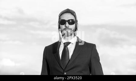 ritratto di uomo d'affari in tuta e cappello pilota su sfondo cielo Foto Stock